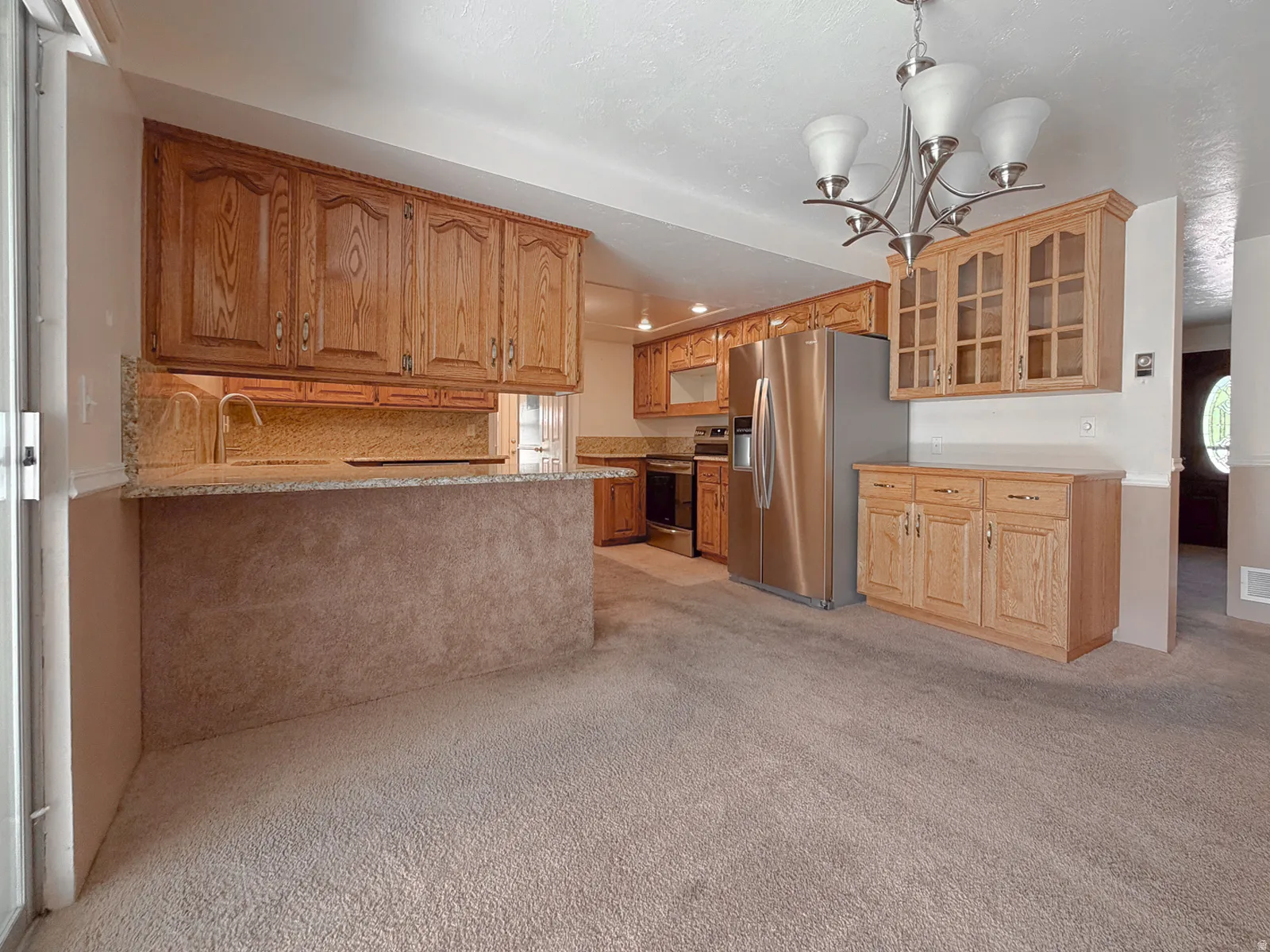 Kitchen featuring wood cabinetry, stainless steel appliances, granite countertops, and a breakfast bar