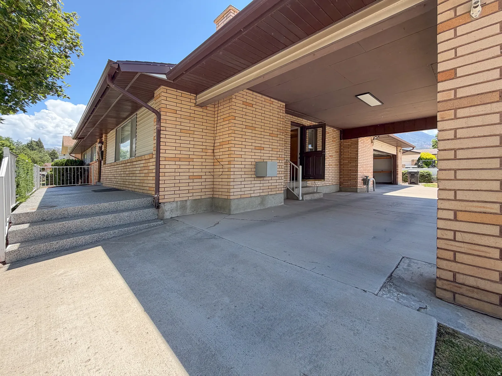Brick exterior with a covered carport featuring recessed lighting
