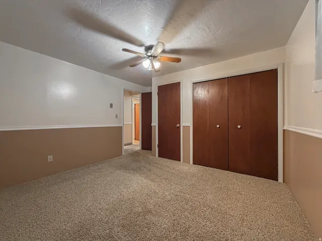 Soft beige wall-to-wall carpeting complements the two-tone wall treatment with a white upper section and beige wainscoting