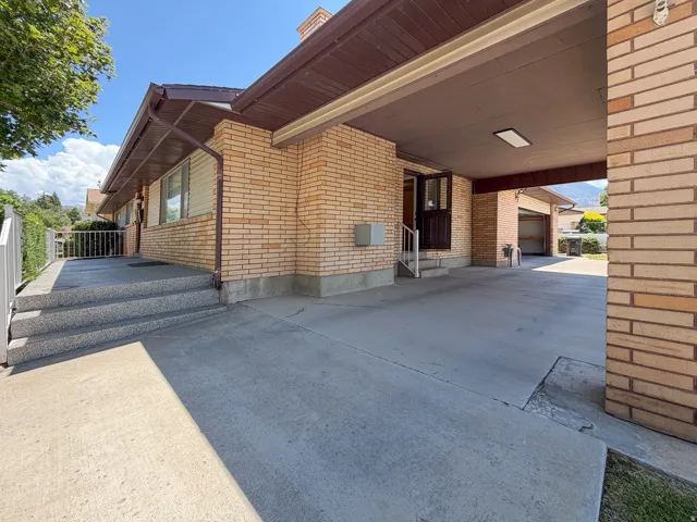 Brick exterior with a covered carport featuring recessed lighting