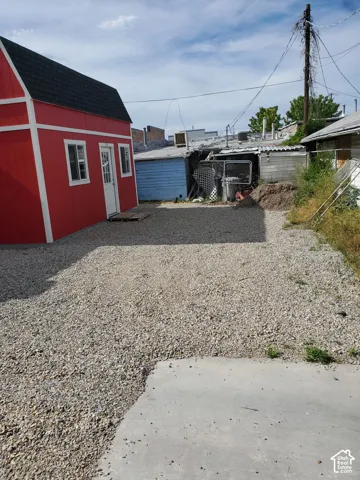 Red outbuilding with white trim and a dark shingle roof