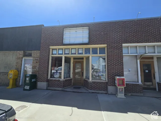 Brick facade building with large storefront windows and a recessed entry