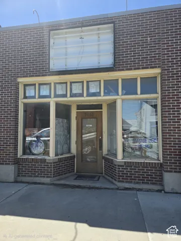 Brick facade with multi-pane display windows, recessed entry door, and a prominent upper sign space