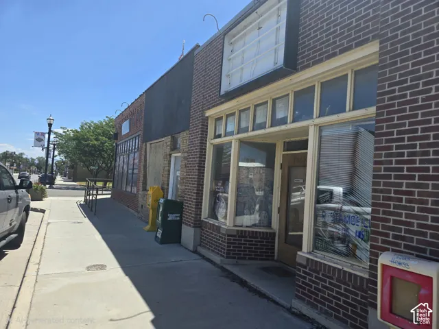 Brick facade with multiple display windows and overhead signage frame