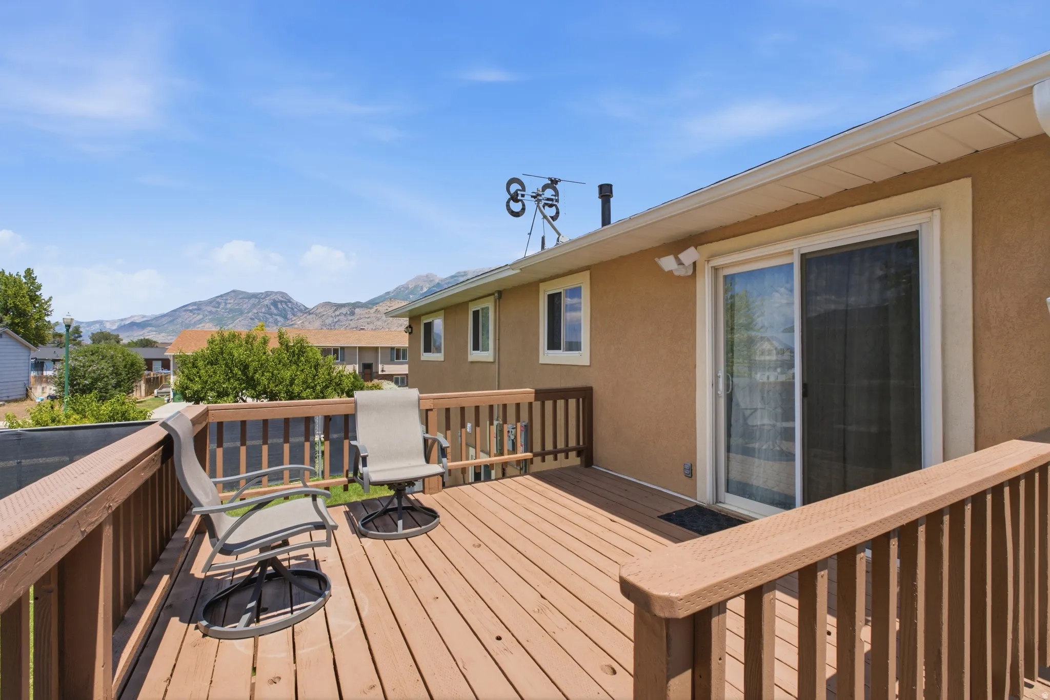 Expansive wood deck with sturdy wood railings, offering mountain scenery