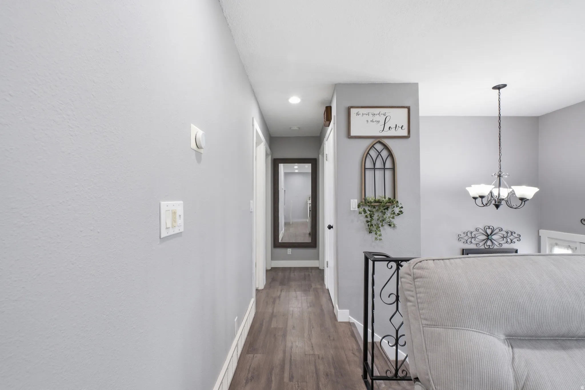 Hallway featuring wood-finish flooring, white baseboards, light gray walls, and recessed lighting