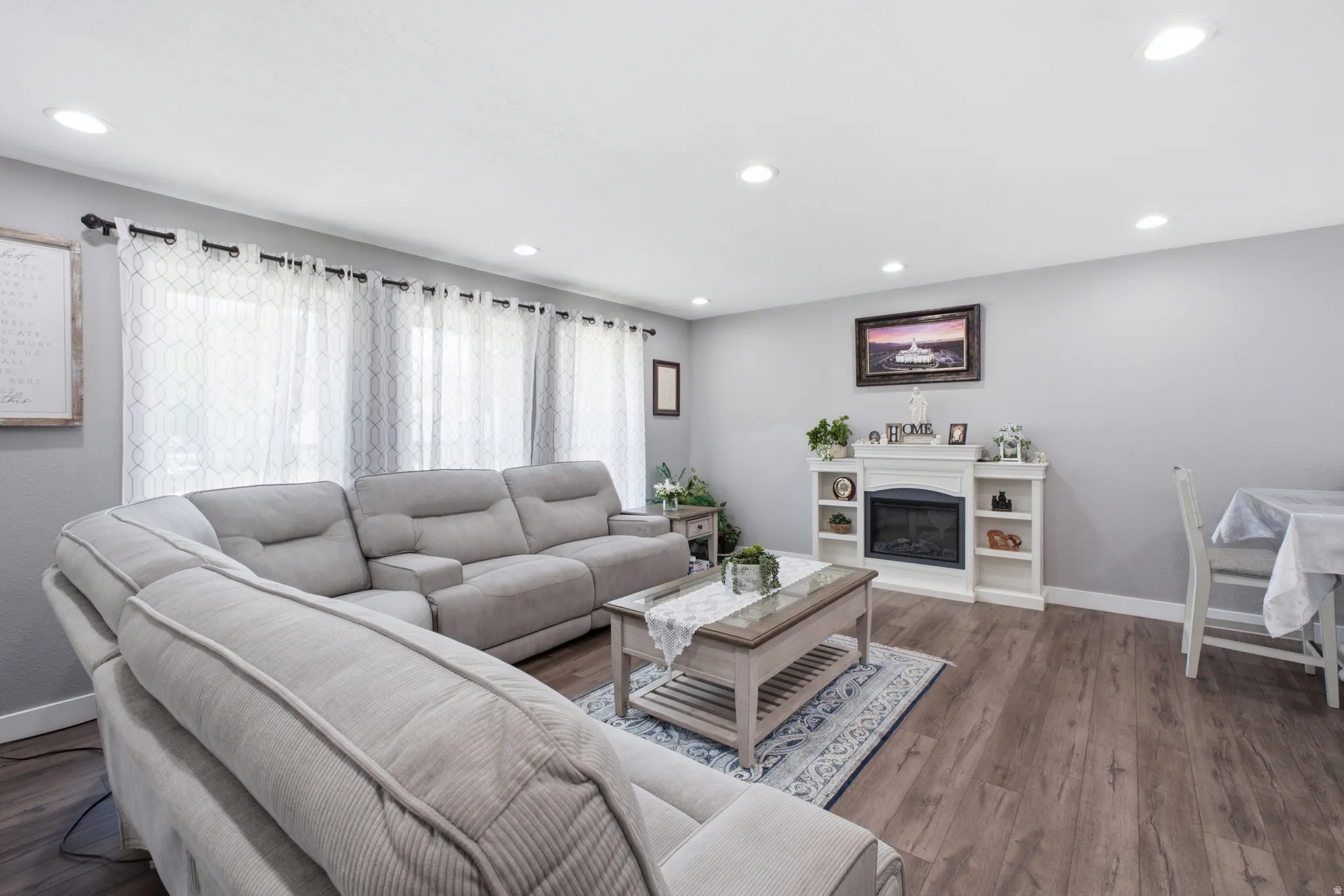 Living room featuring wood-finish flooring, recessed lighting, and large windows