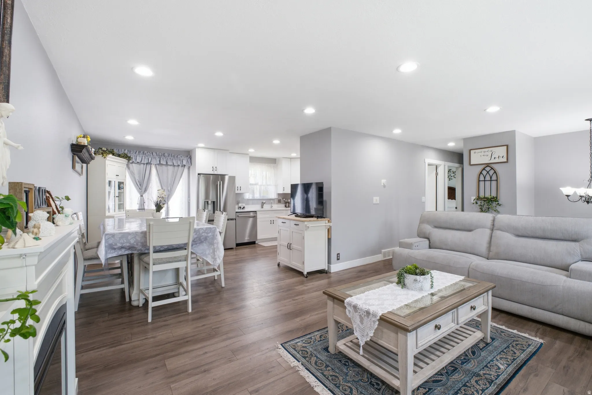 Open-concept living space featuring wood-finish flooring throughout, recessed lighting, and light gray wall tones