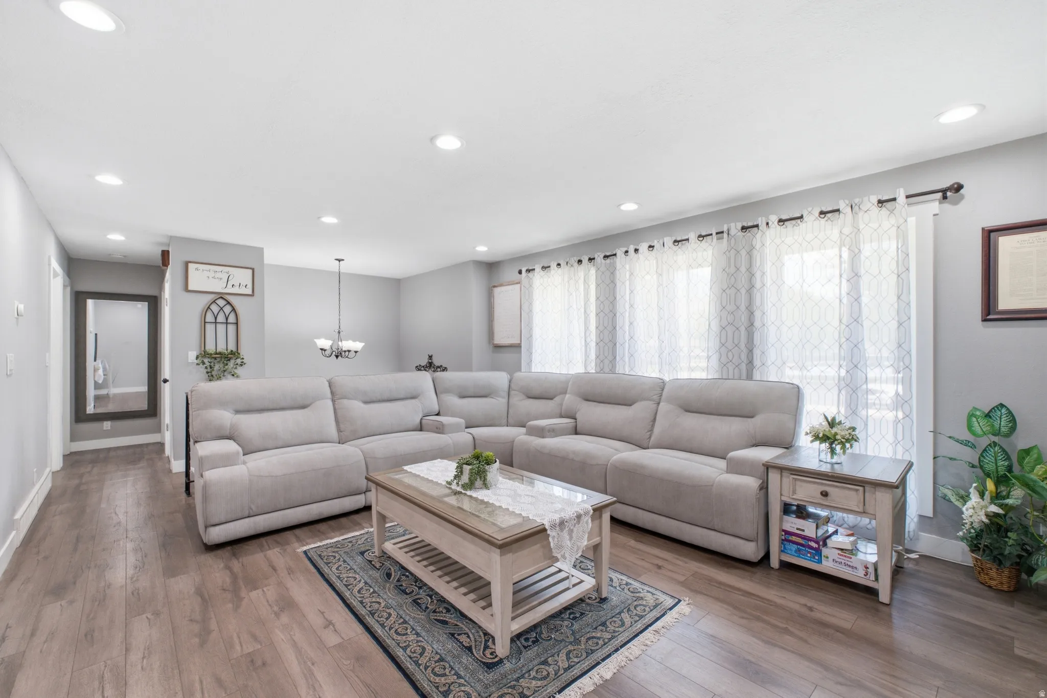 Spacious living area featuring wood-finish flooring, recessed lighting, and light gray walls