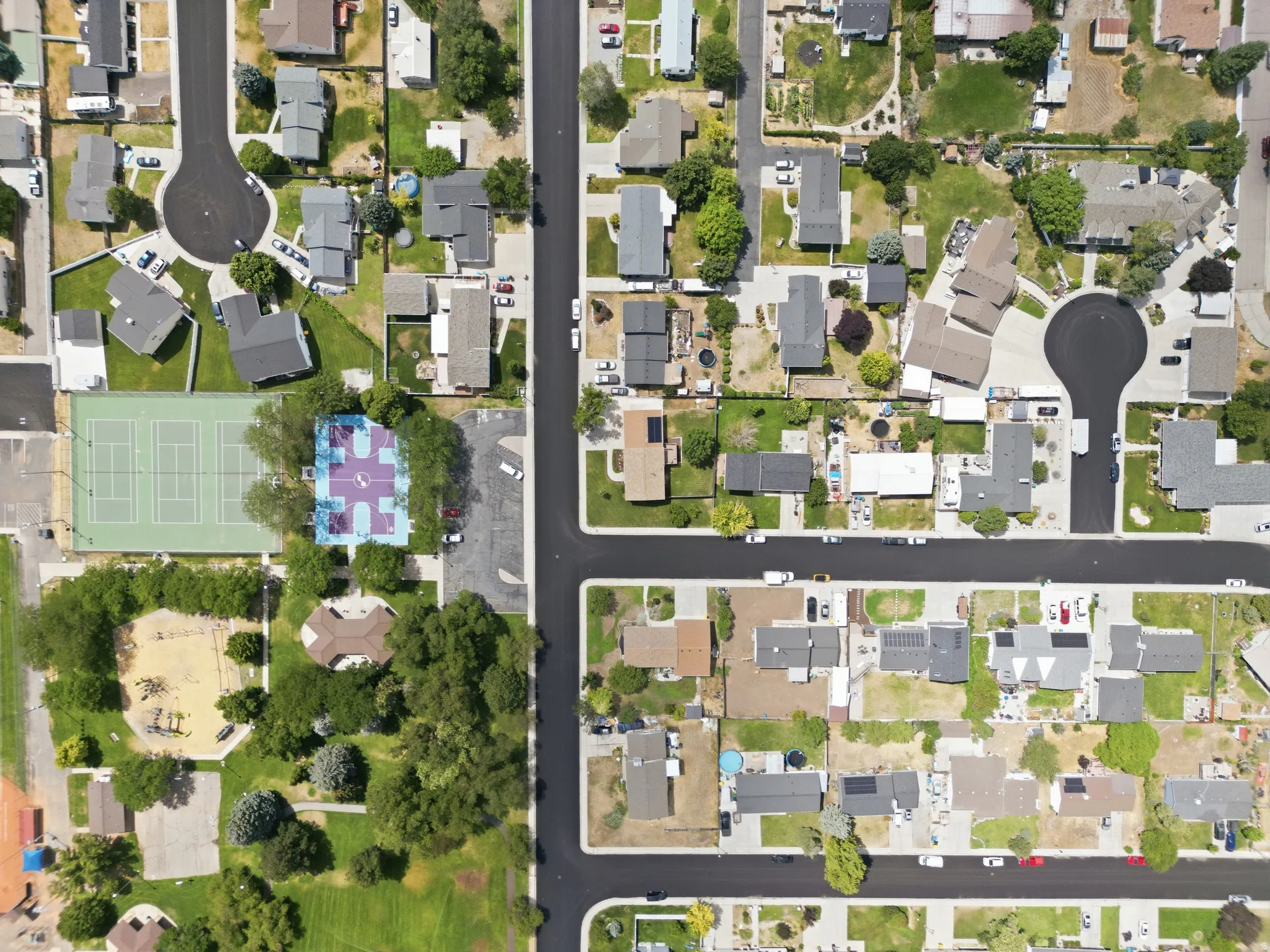 Aerial perspective showcasing a residential neighborhood with a diverse mix of single-family homes, established landscaping, paved streets, and cul-de-sacs