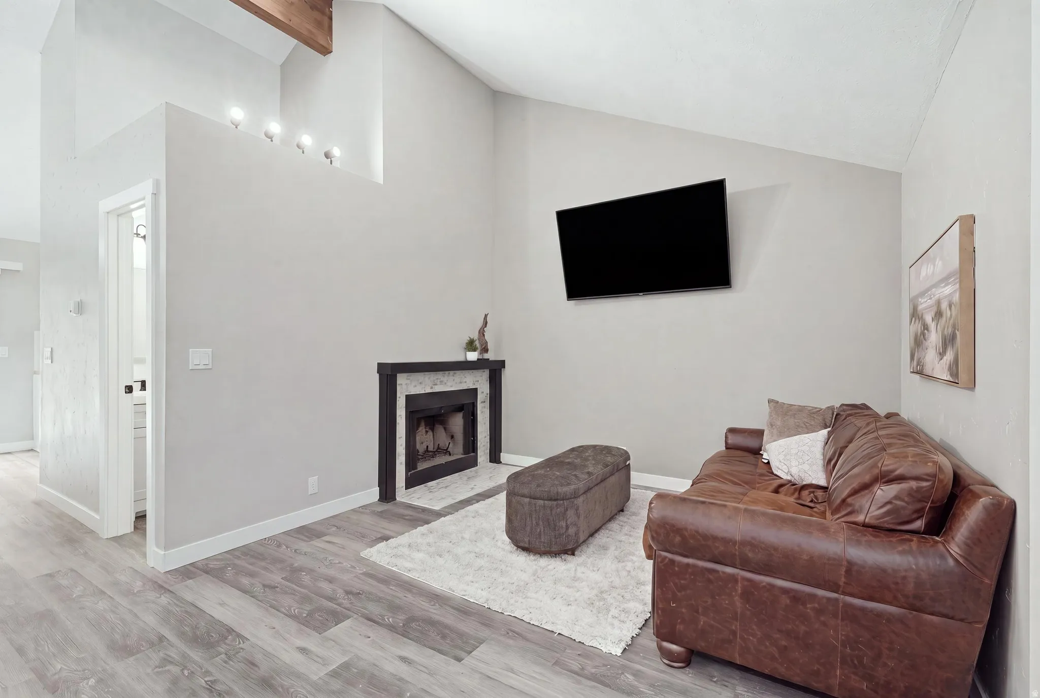 Living room with view of fireplace and door to half bath.