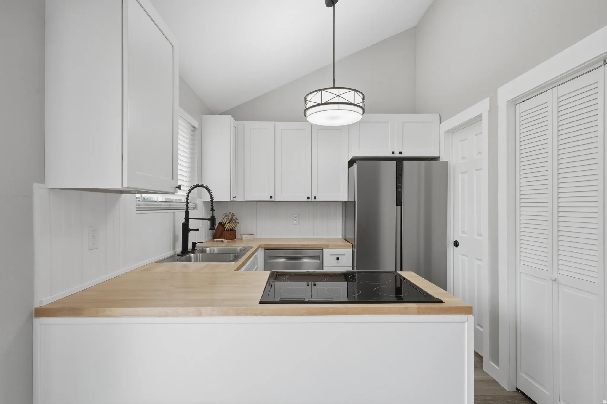 Kitchen with view of both small panty closet and walk in pantry door.