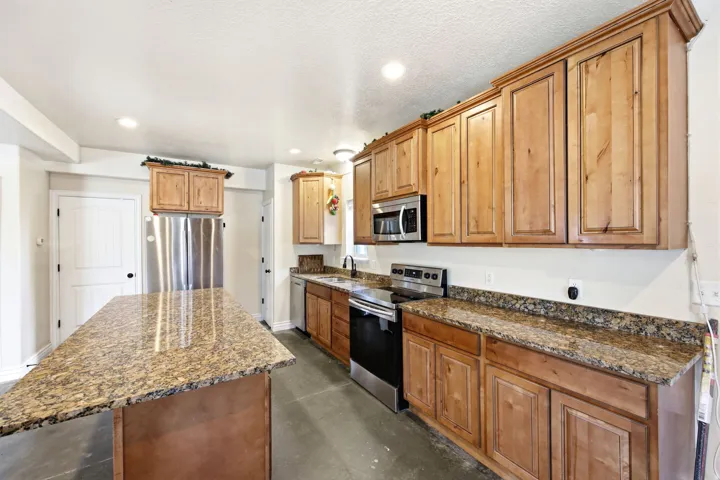 Large Two-story ADU - Kitchen featuring wood cabinetry, stainless steel appliances, and granite countertops