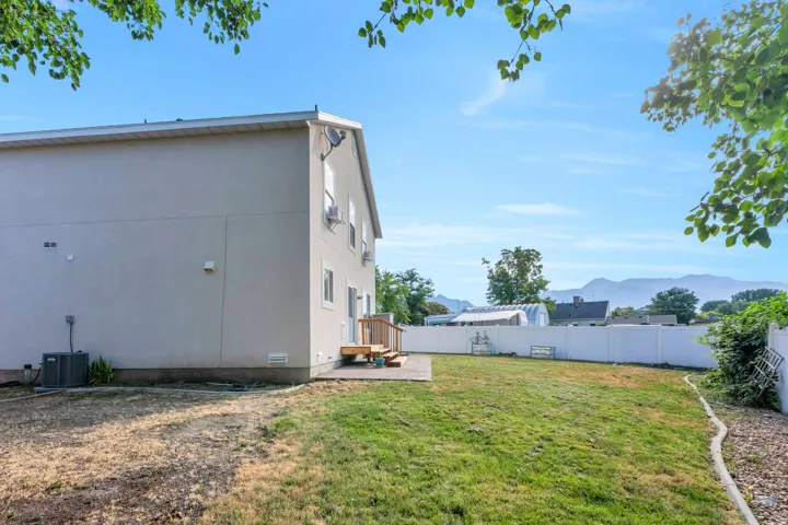 Expansive backyard featuring a white privacy fence and a mountain backdrop