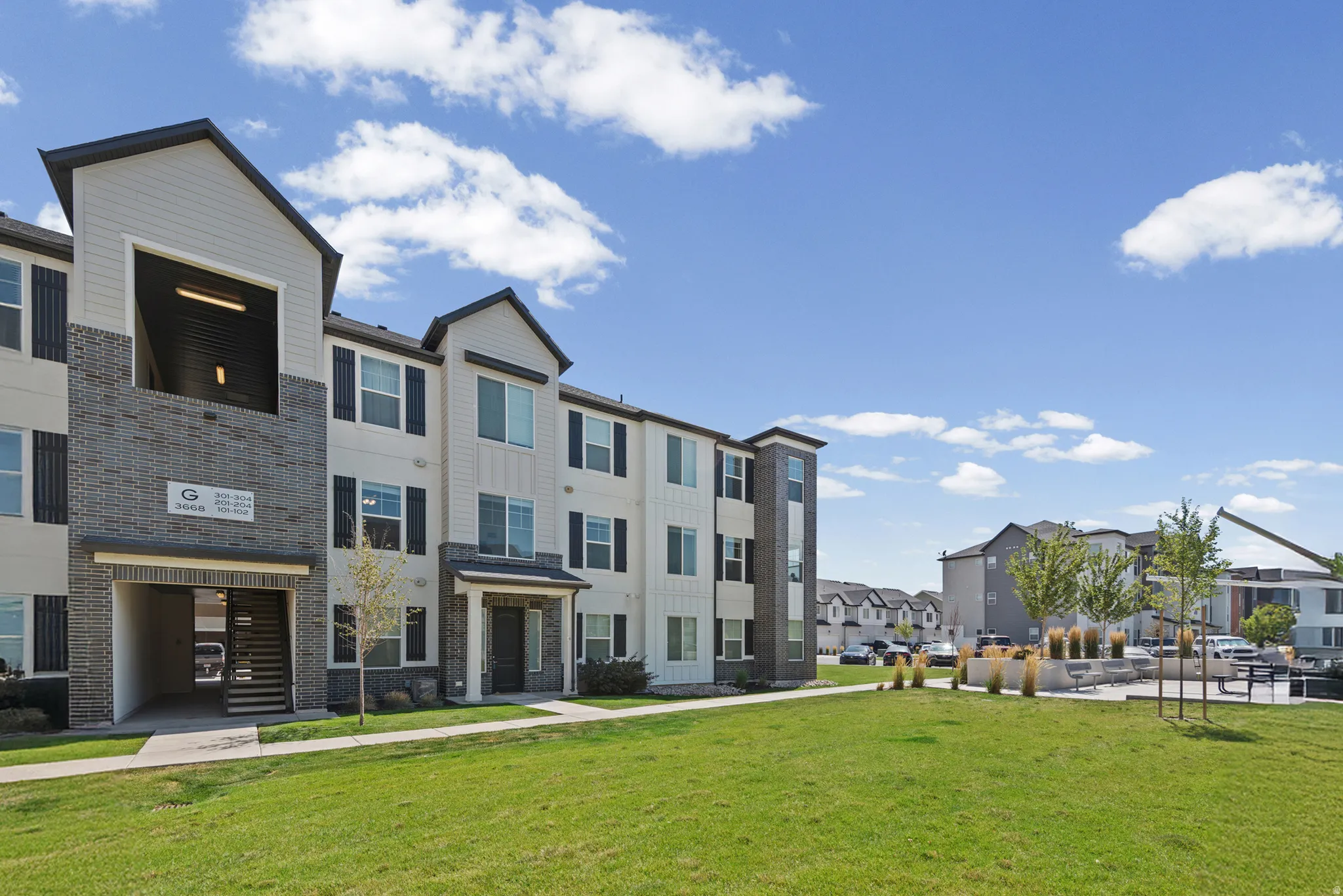 Contemporary multi-story building featuring light siding and dark brick accents