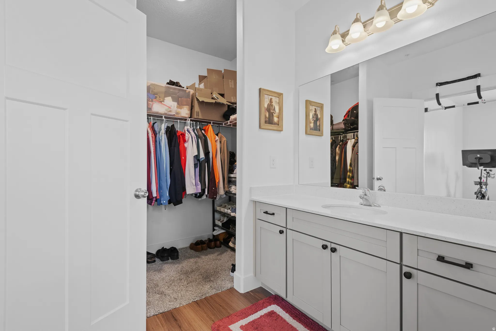 Vanity featuring a stone countertop, an integrated sink, and gray cabinetry with black hardware