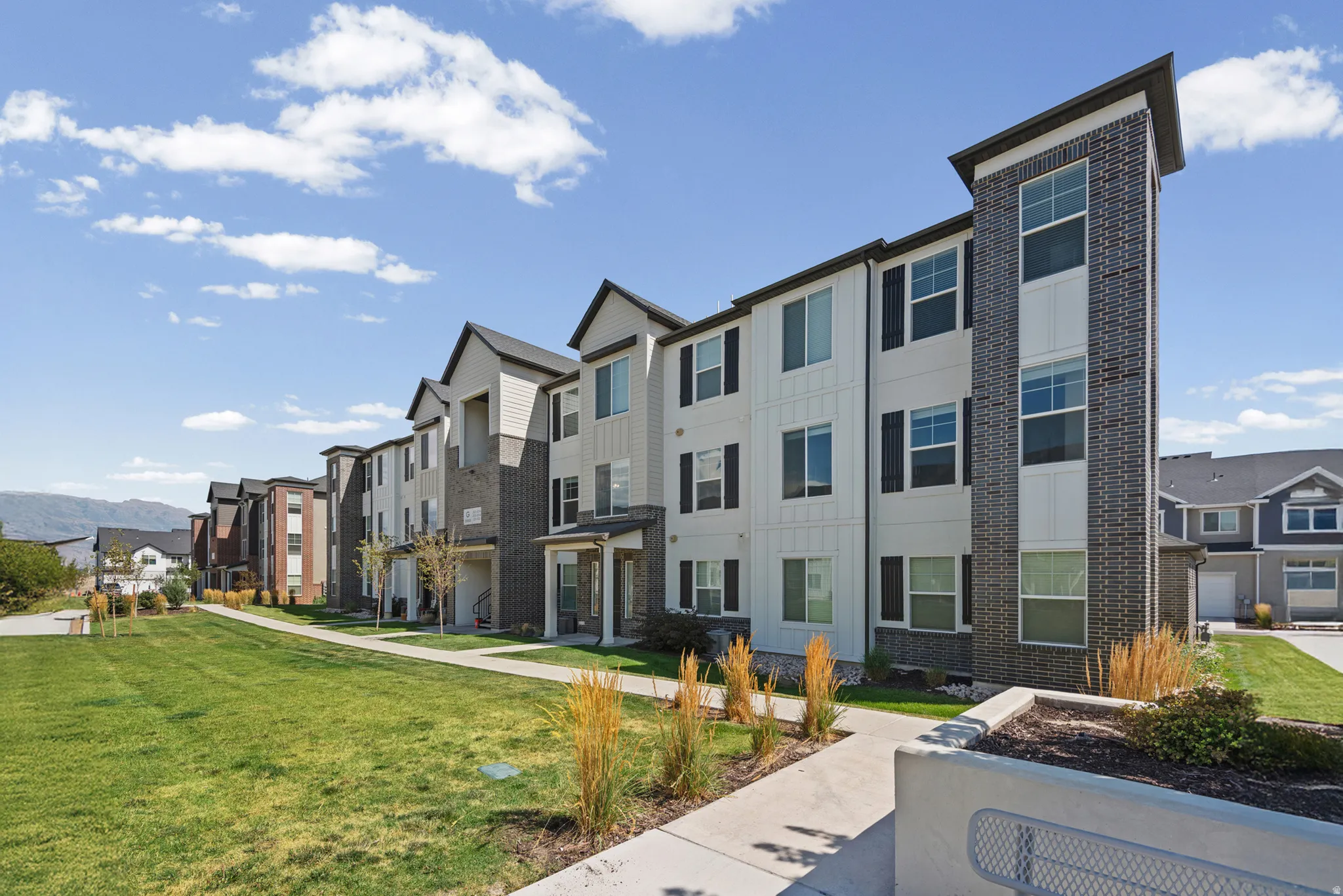 Multi-story residential buildings featuring vertical siding and brick accents