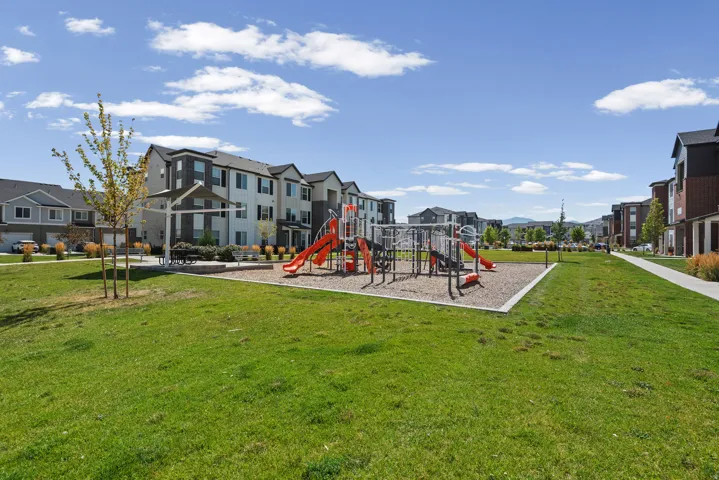 Community green space featuring a playground with slides, swings, and climbing structures