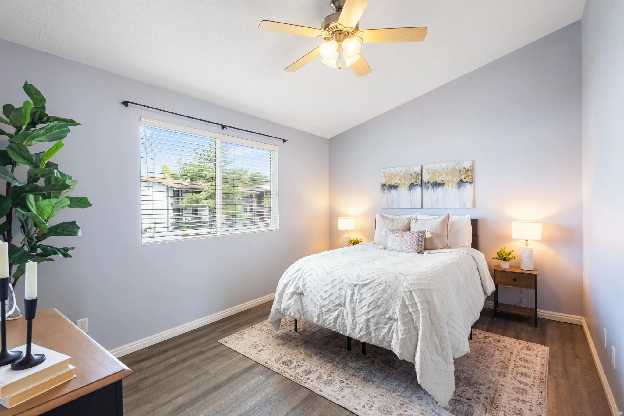 Bedroom featuring vaulted ceilings, a ceiling fan, and wood-finish flooring