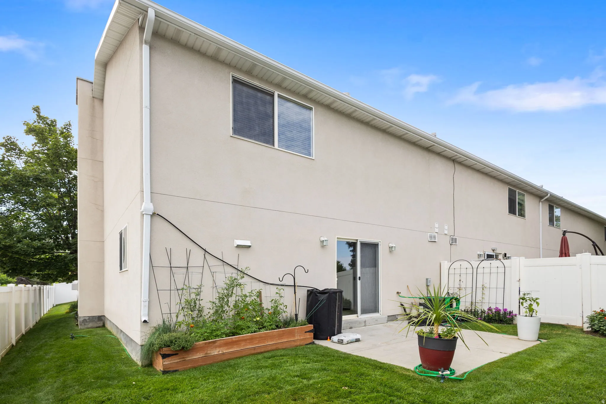 Rear exterior featuring a patio, sliding glass door, and stucco siding