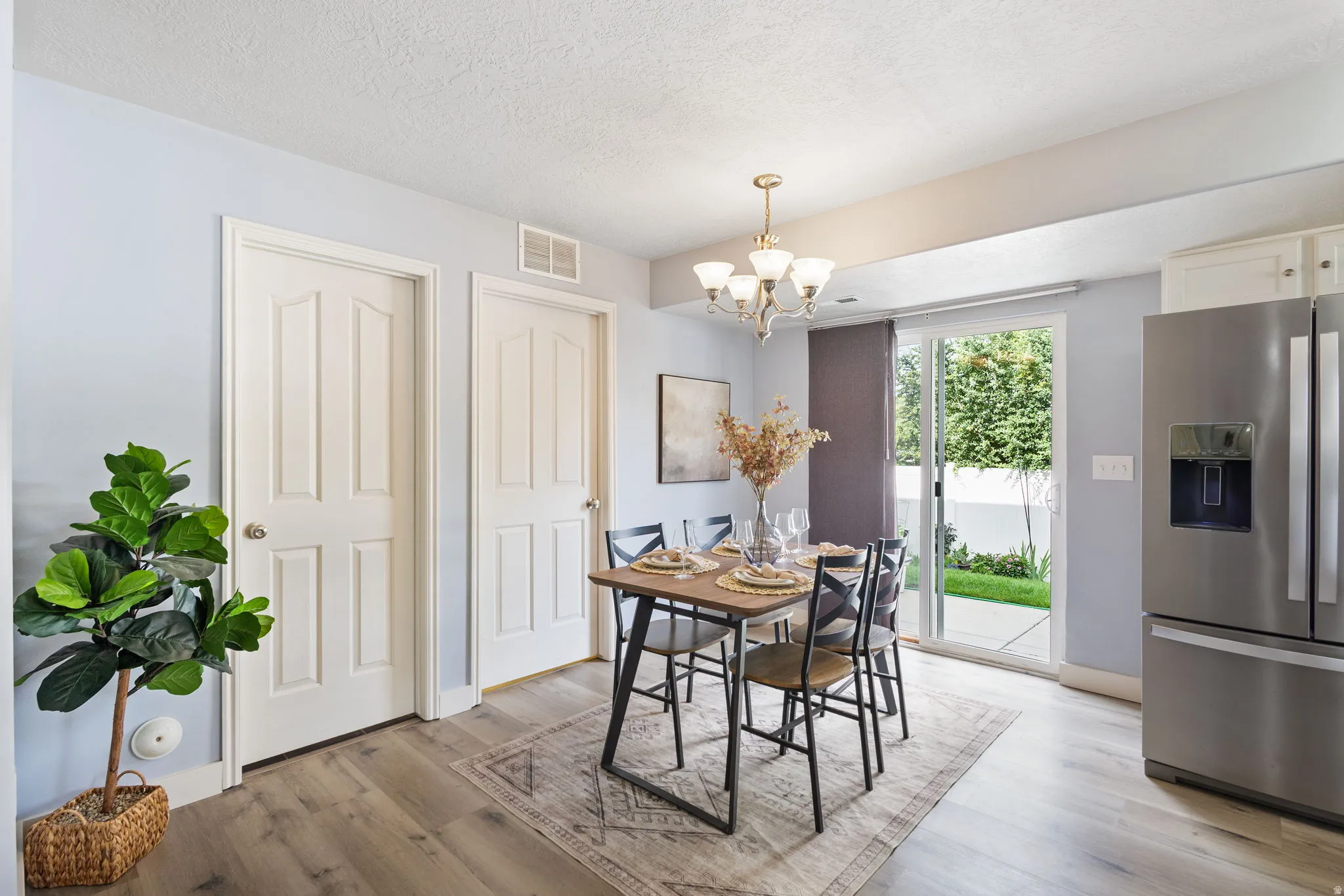 Dining area featuring wood-finish flooring and a brass chandelier
