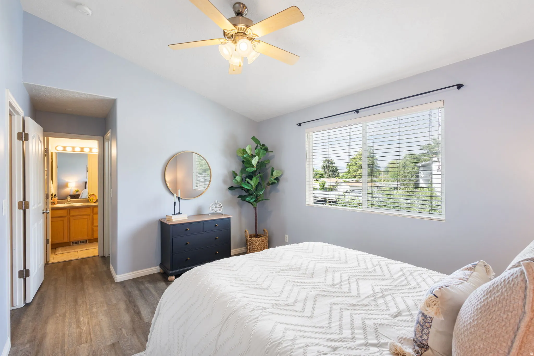 Bedroom featuring vaulted ceilings, wood-finish flooring, and a ceiling fan with integrated lighting