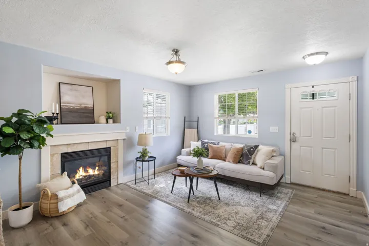 Living area featuring wood-finish flooring, a fireplace with a stone surround and mantle, and a built-in recessed niche