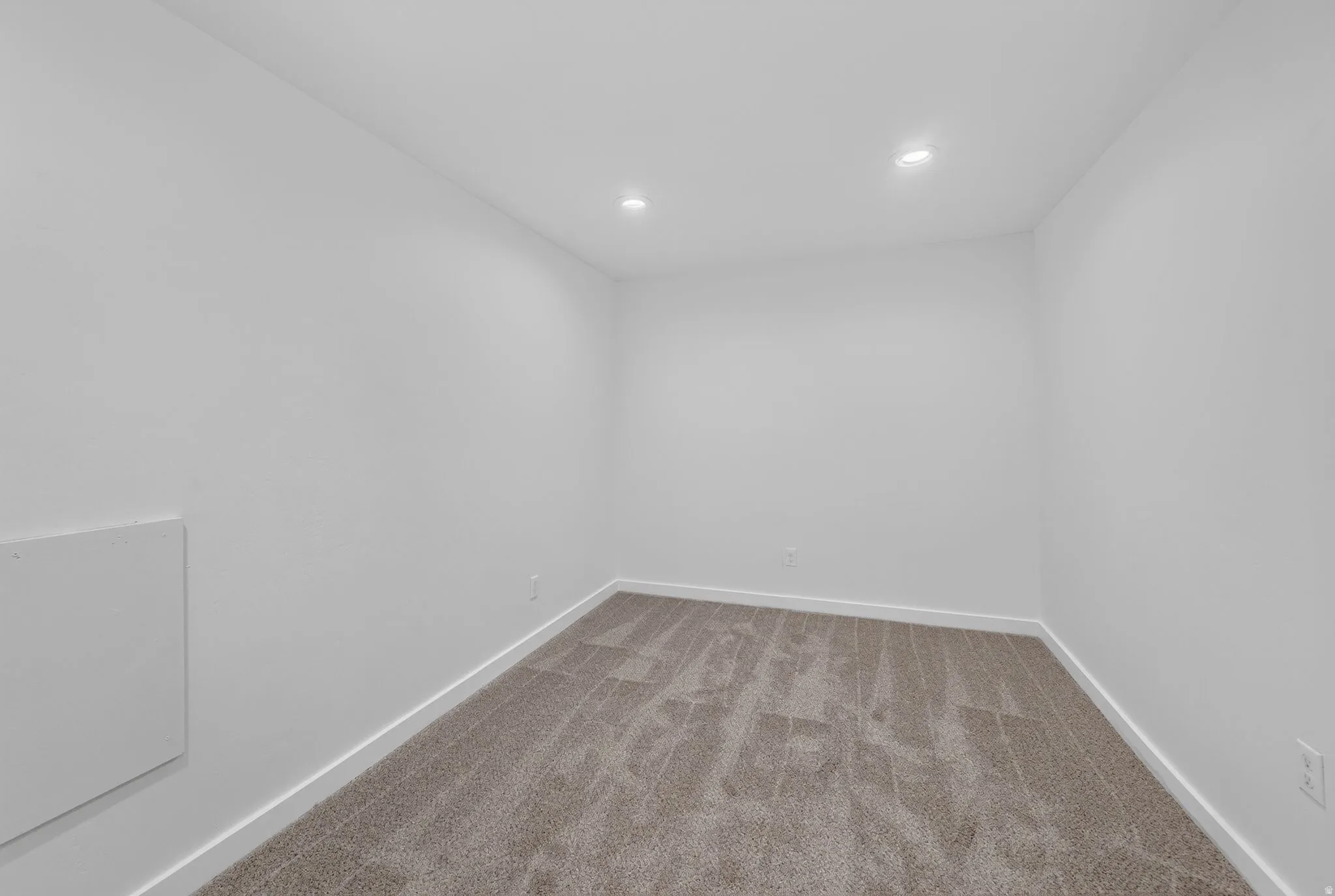 Neutral-toned carpeting paired with crisp white walls and recessed ceiling lighting