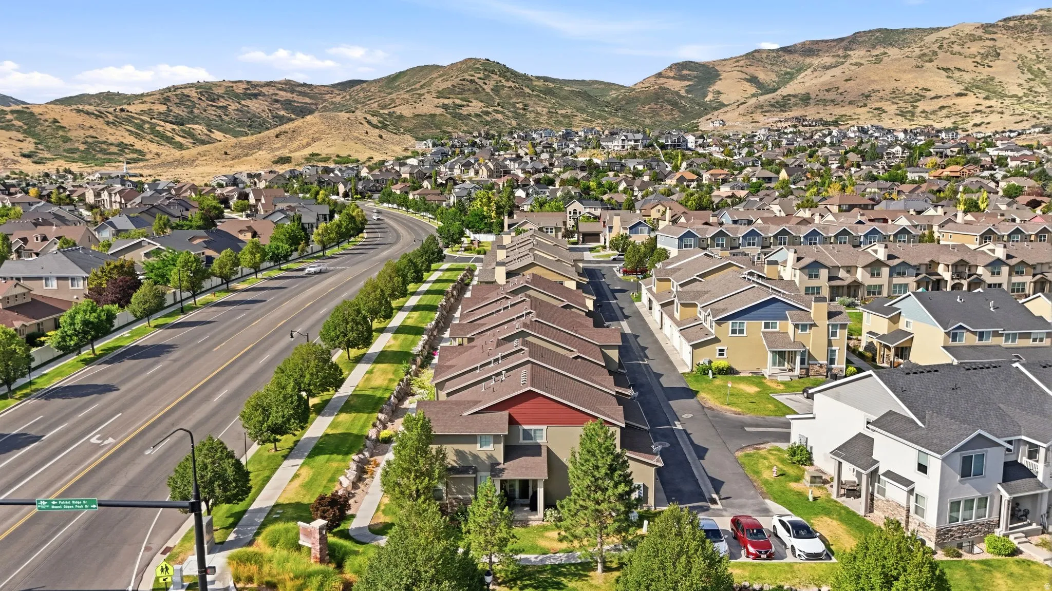 Expansive neighborhood featuring a variety of residential properties, a multi-lane road with a tree-lined median, and established landscaping