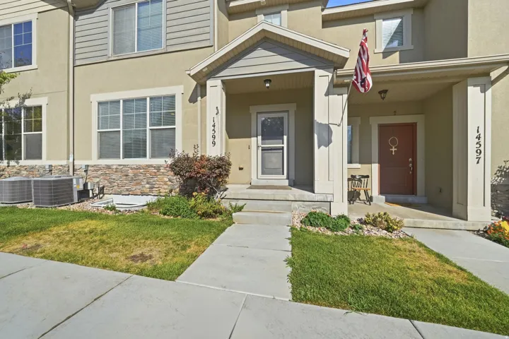 Exterior featuring a stone facade accent, stucco finish, and multiple windows