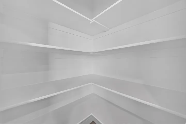 Corner shelving system featuring multiple white shelves