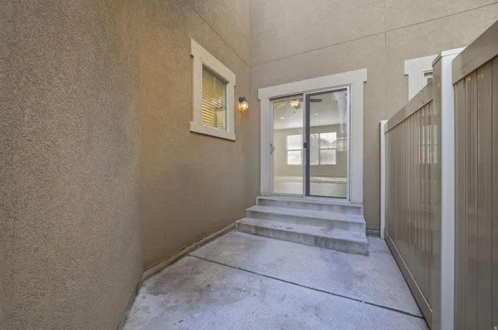 Private exterior patio featuring concrete flooring and a privacy fence