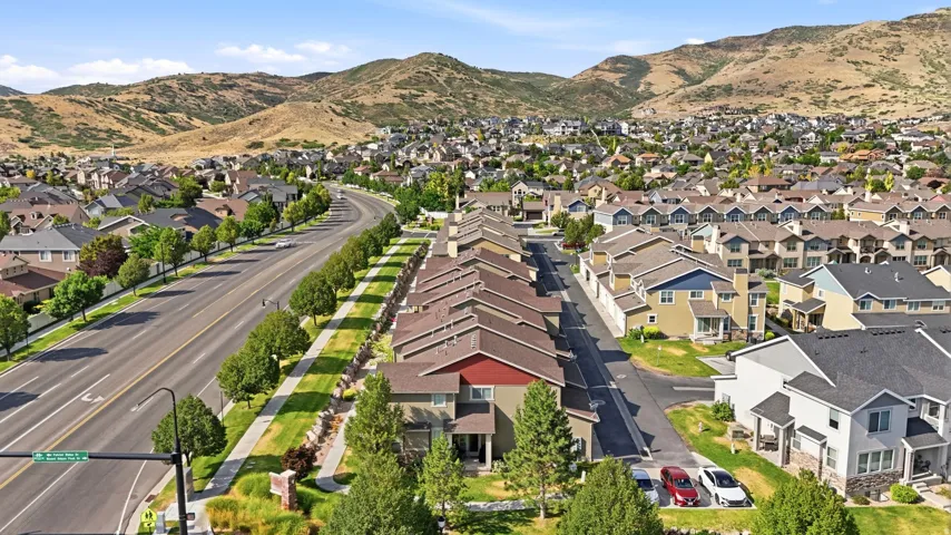 Expansive neighborhood featuring a variety of residential properties, a multi-lane road with a tree-lined median, and established landscaping