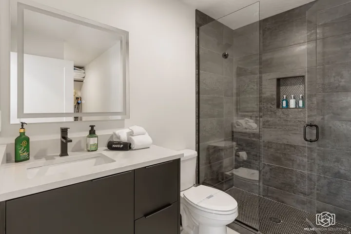 ADU bathroom featuring a floating vanity with integrated sink, quartz-finish countertop, and matte black faucet
