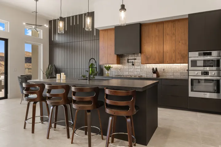 Modern kitchen featuring a large central island, stainless steel sub zero and Bosch appliances, and a mosaic tile backsplash