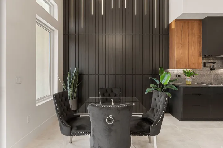 Tall window with transom, vertical slatted accent wall, linear pendant lighting, built-in cabinetry, and tile flooring