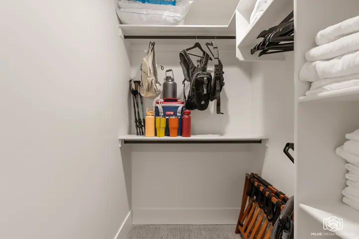 ADU built-in closet system featuring white shelving, hanging rods, and ample storage compartments