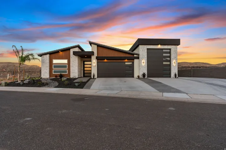 Contemporary architectural exterior featuring stone veneer, wood-finish siding, and a low-slope roofline