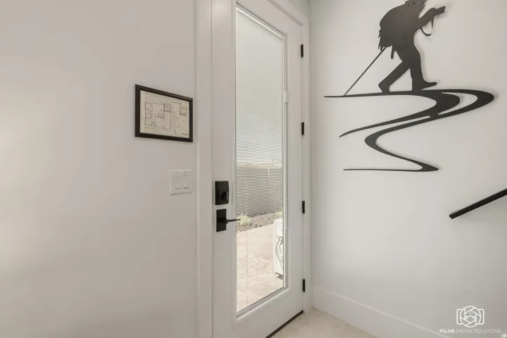 ADU full-light white entry door with matte black hardware and a visible exterior concrete patio