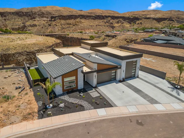 Modern exterior with white stone, multi-level rooflines, and an integrated two-car garage