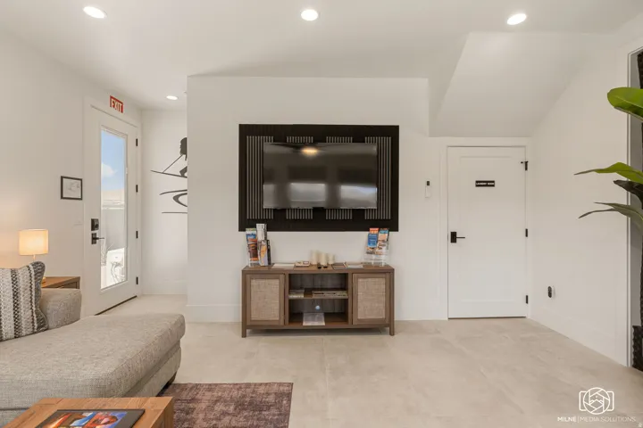 ADU open-concept living space with recessed lighting, light-toned tile flooring, and a wall-mounted television feature