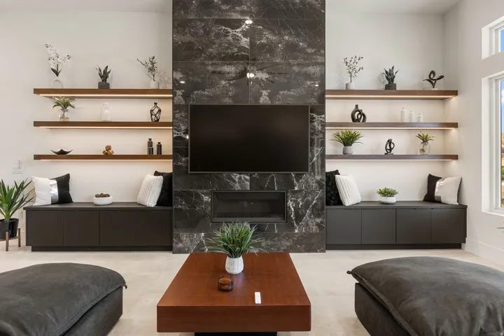 Integrated entertainment wall featuring a dark stone-clad fireplace and television
