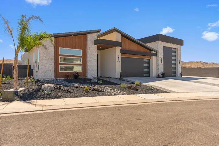 Contemporary exterior featuring stacked stone, wood-finish siding, and a dark tile roofline