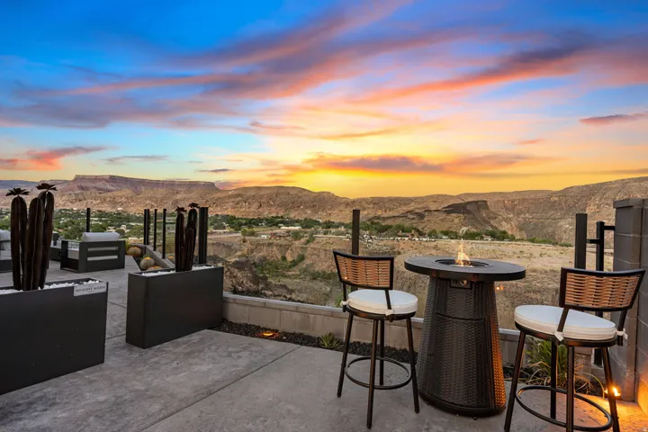 Outdoor patio with a concrete surface, glass railing, and desert mountain scenery