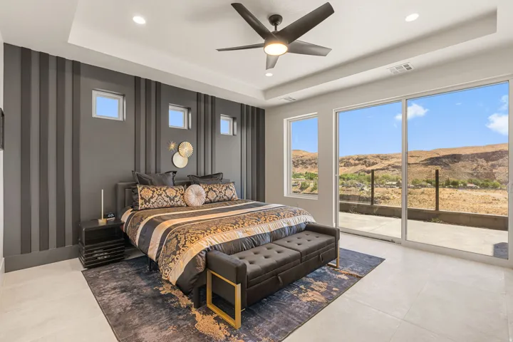 Primary bedroom featuring a tray ceiling, recessed lighting, and a ceiling fan