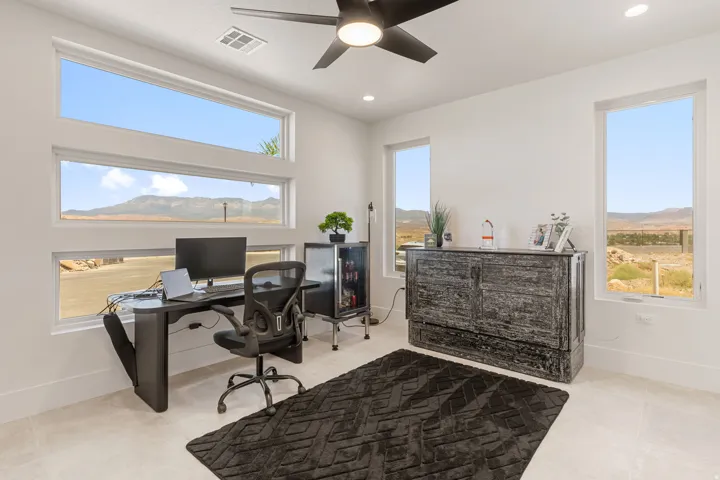 Light-filled room featuring multiple windows with mountain scenery, recessed lighting, a ceiling fan, and light-toned tile flooring