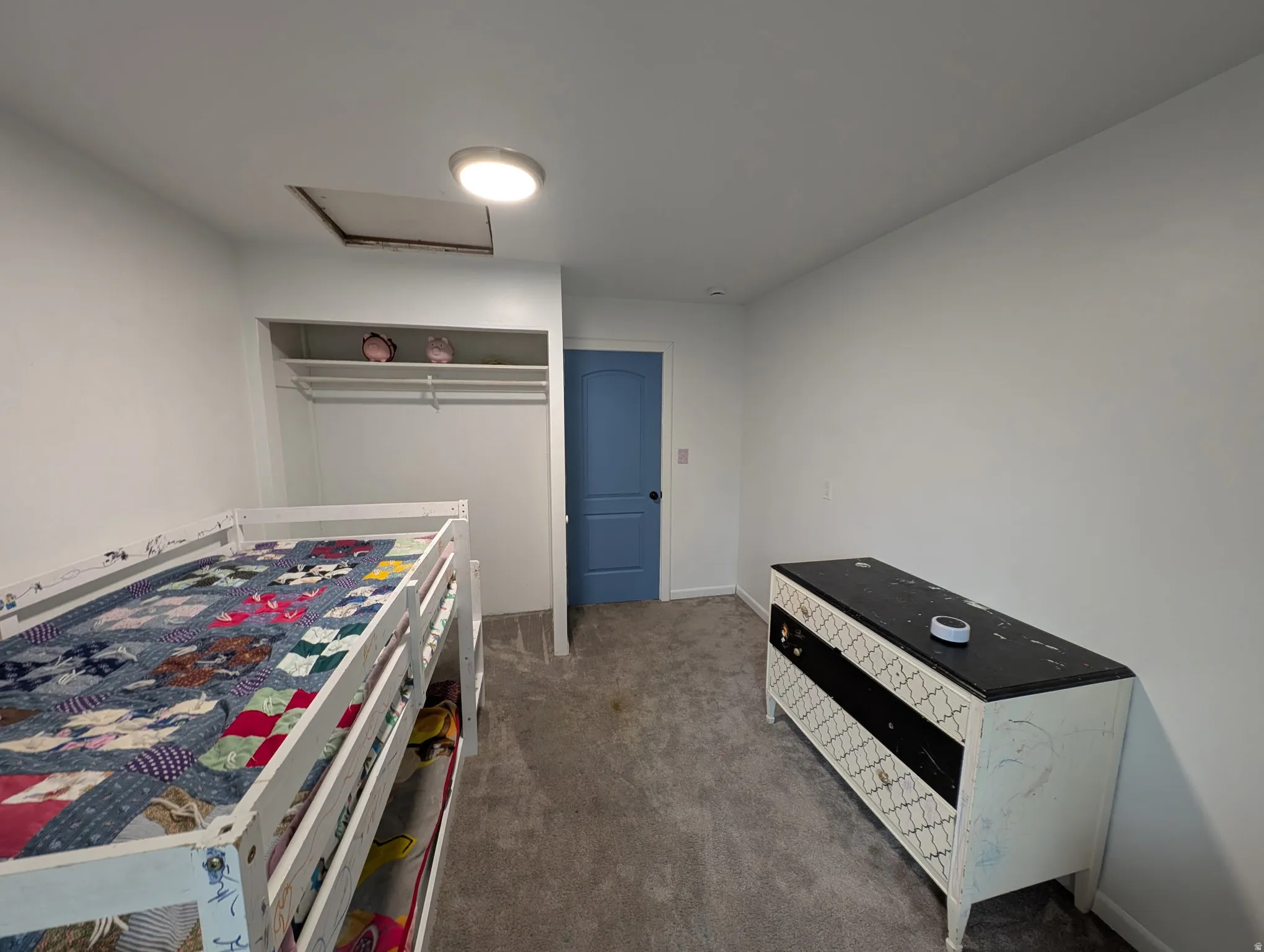 Wall-to-wall carpeting with an open closet featuring shelving and a hanging rod