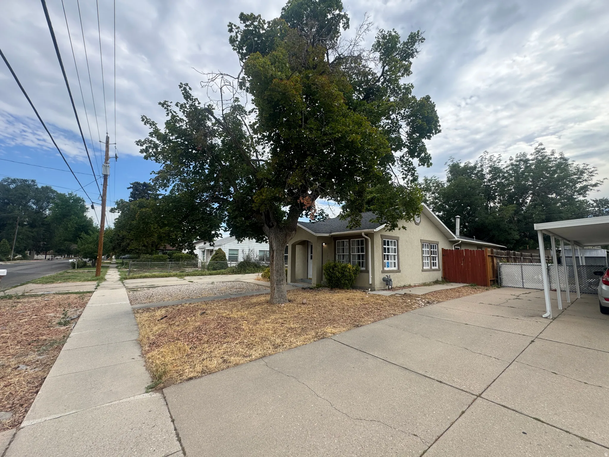 Stucco exterior residence with a concrete driveway and an attached carport