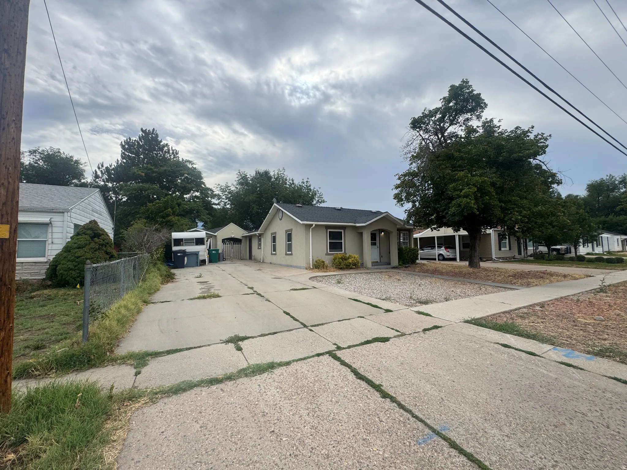 Single-story exterior with light-colored siding, a covered entry, and a paved driveway extending to the rear of the property