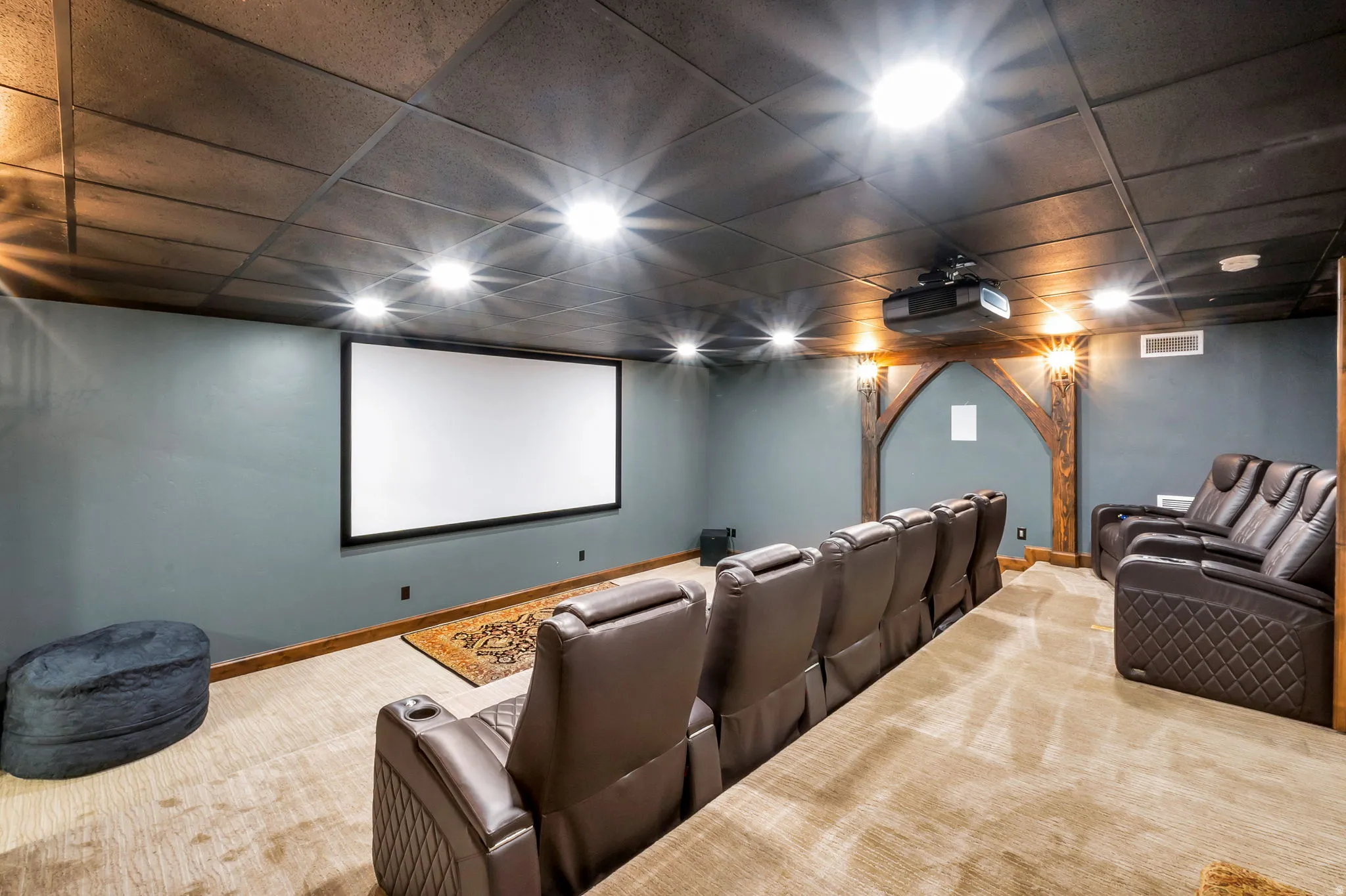 Dedicated home theater featuring a large projection screen and ceiling-mounted projector